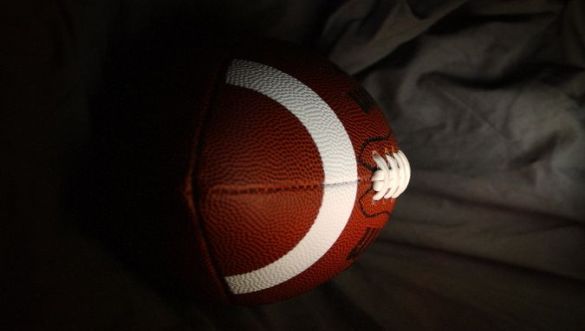 Photo of a football with a gray background.